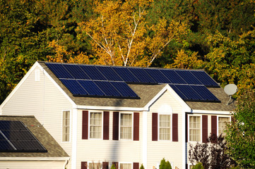 Obraz premium solar panel installed on the house roof with autumn trees