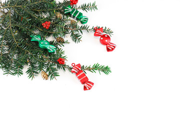 Christmas decoration with candy and pine branch on white background