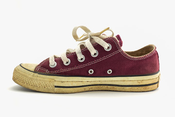 Old red sneaker isolated on white background.