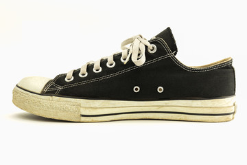 Old black sneaker isolated on white background