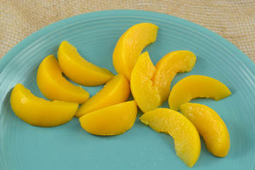 Canned peach slices on blue plate