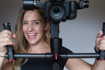 Fototapeta na wymiar Professional woman videographer with gimball video slr