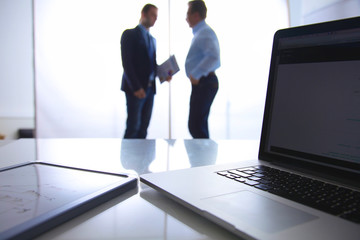 Focus on laptop the table. Blurred people background