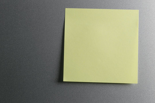 Empty yellow paper sheet on refrigerator door for design.