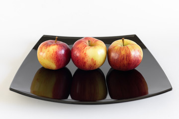 three apples in line on a square plate