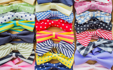 Collection of colorful and varieties of pattern bow ties texture background on a wooden tray