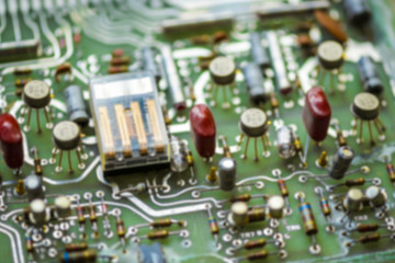 blurred abstract background of printed circuit board with electronic components