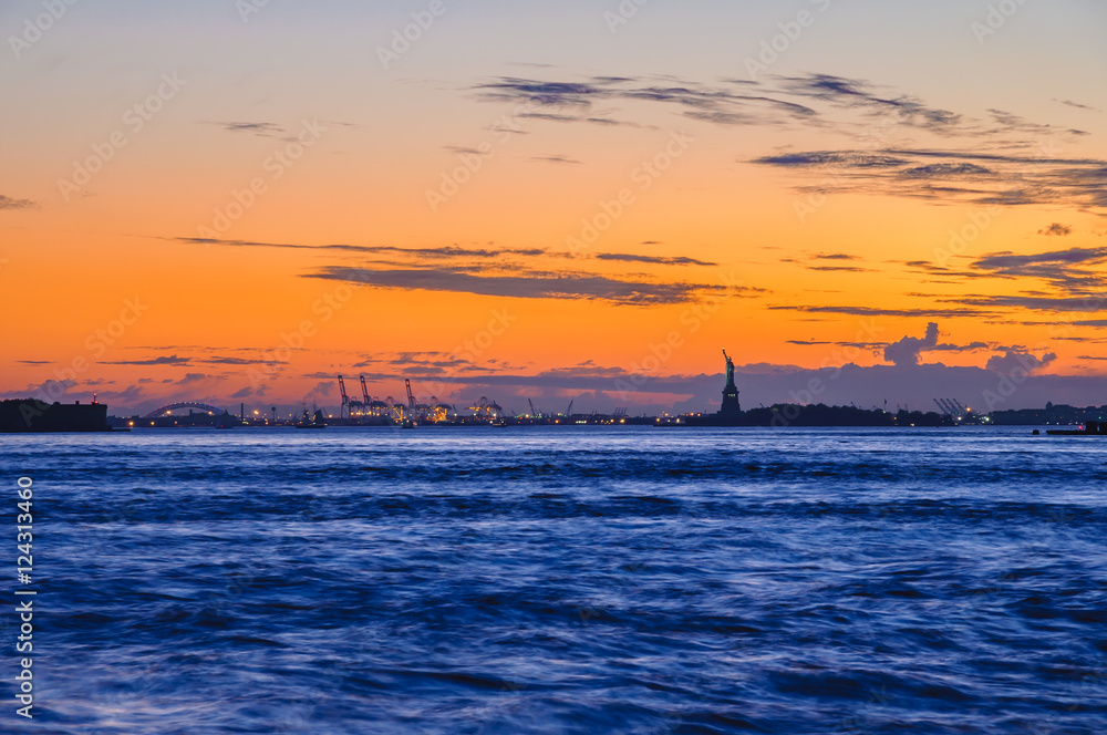 Wall mural Liberty Island and harbor of New Jersey at evening after sundown, New York, USA