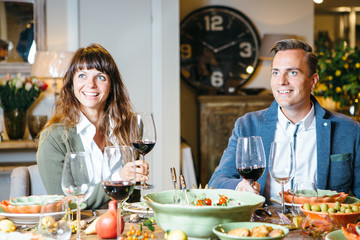 Pair listening to toast, holding wine glasses.