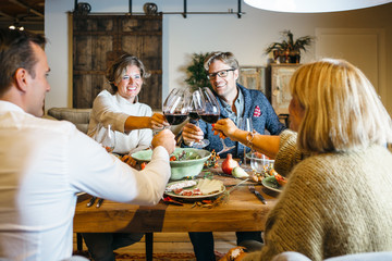 People cheering at celebration with wine glasses.