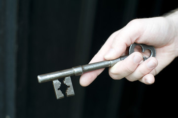 Hand holding a large antique style key