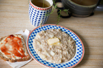 plate of porridge and   piece of bread with jam