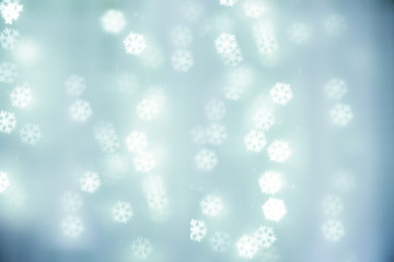 Blue background of snow flakes. Christmas lights