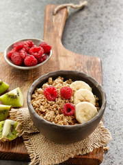 bowl of granola with banana and raspberries