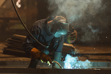 Industrial Worker at the factory welding closeup.