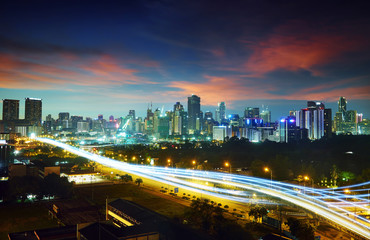 Abstract and car lighttrail  background, city skyline downtown background and highway interchanged nigh view .