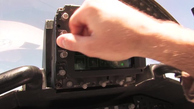 F/A-18 cockpit technology, man uses communications technology inside fighter jet.