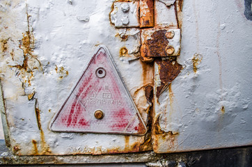 old red emergency triangle / One red warning triangle / Red emergency triangle at metal door rusty corroded texture background / Metal door gate texture