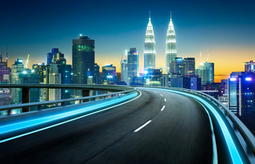 Blue neon light highway overpass motion blur with city  skyline background , night scene .