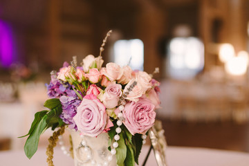 Table setting at wedding reception. Wedding floral decoration closeup.