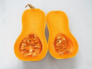 Bottle shaped pumpkin. Butternut squash upon old wooden background, halved.