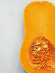 Ripe juicy pumpkin. Butternut squash upon old wooden background, halved. Copy space for your text.
