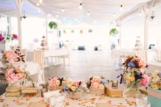 Table Setting At Country Wedding Reception, Wedding Floral Decoration, Wrapped Books And Candles. Overhead View.