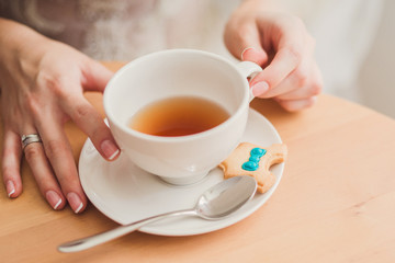 Closeup of bride hands with a cup of tea in cafe. Wedding ring on her finger.