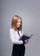 Stylish girl with the book on a gray background in the studio