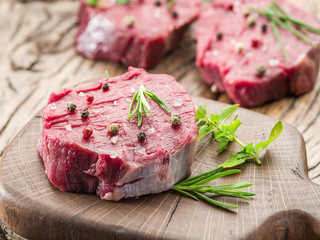 Pieces of beef tenderloin on the wooden cutting board.