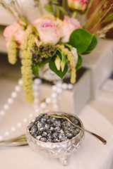 vintage vase with blueberries on the background of flower arrangement as a decoration of wedding candy bar