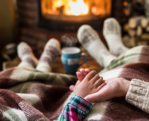 Warming and relaxing near fireplace. Mother and daughter holding © volff