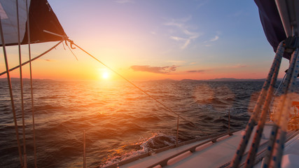 Beau coucher de soleil en pleine mer avec voilier.