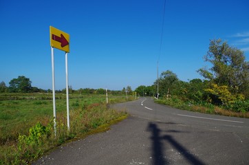 田舎道と矢印の標識