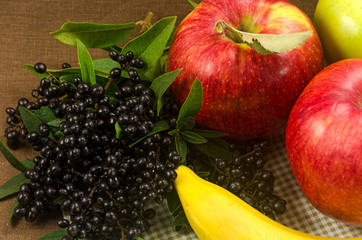 Naklejka na ściany i meble Composition with bananas, apples and dark wild berries