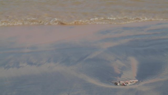 Waves on beach, a tiny wave breaks on the beach.