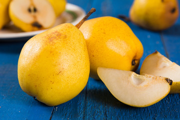 Fresh ripe organic yello pears on blue rustic wooden table, natural background, diet food.