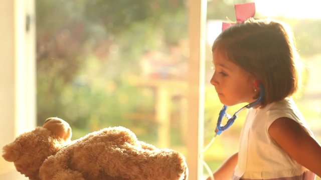 little cute Girl Playing Doctors with Doll child role play bright future