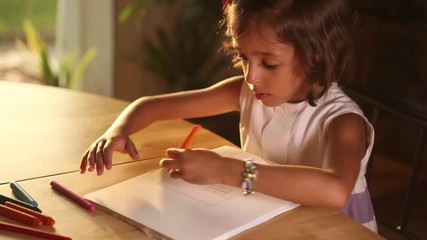 Little girl writing and drawing Doing homeworks adorable dedicated studying child cute young pupil