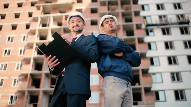 Two men are showing a thumb near the construction