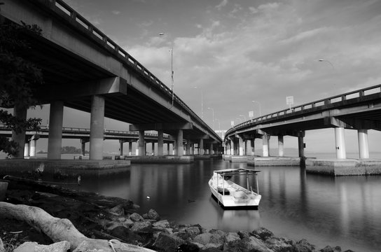 Fototapeta black and white image a boat anchored between two bridge.blurred