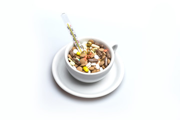 Medical capsules and tablets inside coffee cup