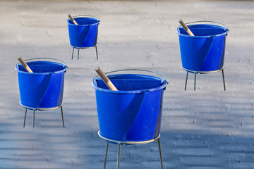 Reinigungswasser im blauen Plastikeimern mit Wassertropfenhinter