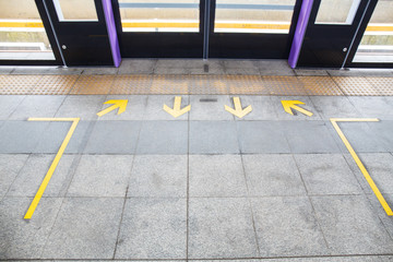 Arrow sign on floor at the sky train station