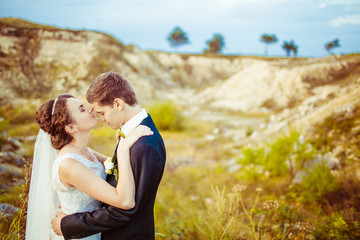 Bride tries to kiss groom's forehead while they pose on the yell
