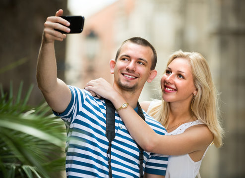 young traveling couple taking selfie.