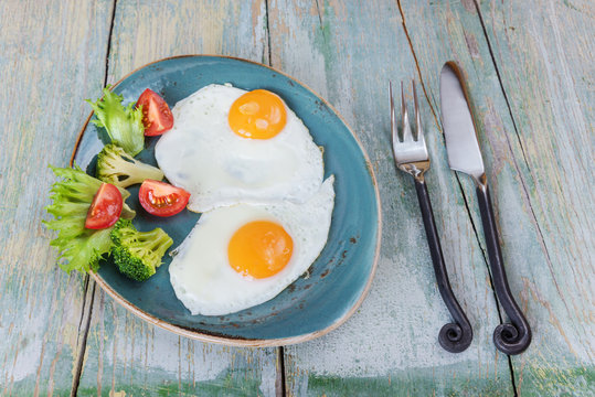 Two fried eggs and vegetables
