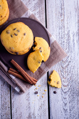 Homemade Pumpkin Spice Cookies with chocolate chips or drops on Halloween,cinnamon sticks. Wooden background. Copy space