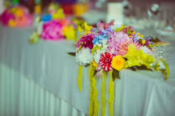 Yellow garlands hang from the gorgeous bouquets standing on the