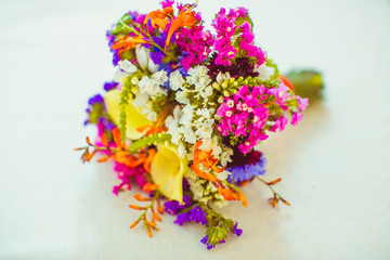 Rich wedding bouquet made of different colored flowers lies on t